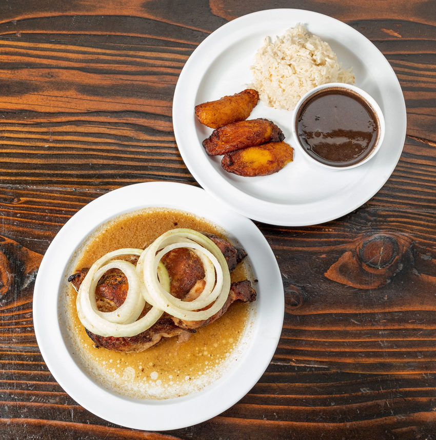half a chicken with garlic lemon sauce top with onions. Served with rice, black beans, and plantains